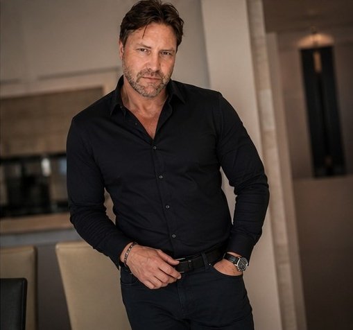 A close portrait of Jonny in a black shirt, lit with a restrained and intimate mood.